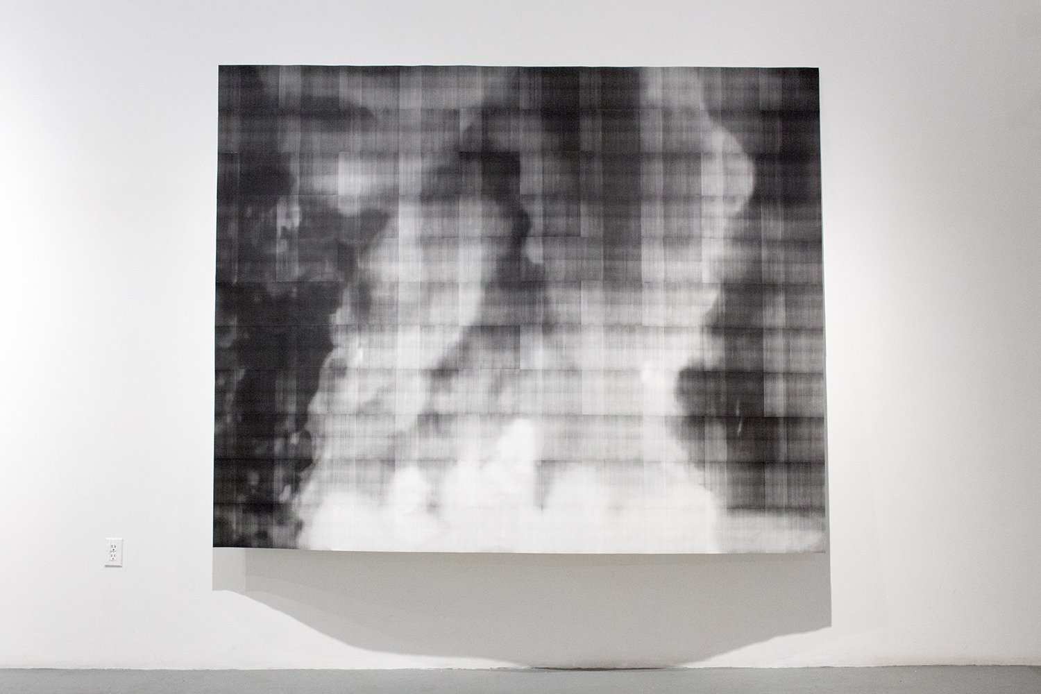 Large black-and-white toner print composed of blurred horizontal and vertical bands forming an indistinct scene of figures and smoke.